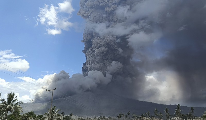Warga berkendara dengan latar belakang Gunung Lewotobi Laki Laki memuntahkan material vulkanik saat terjadi letusan di Flores Timur, Indonesia, Sabtu, 9 November 2024.(Photo by ARNOLD WELIANTO / AFP) Warga berkendara dengan latar belakang Gunung Lewotobi Laki Laki memuntahkan material vulkanik saat terjadi letusan di Flores Timur, Indonesia, Sabtu, 9 November 2024.(Photo by ARNOLD WELIANTO / AFP)