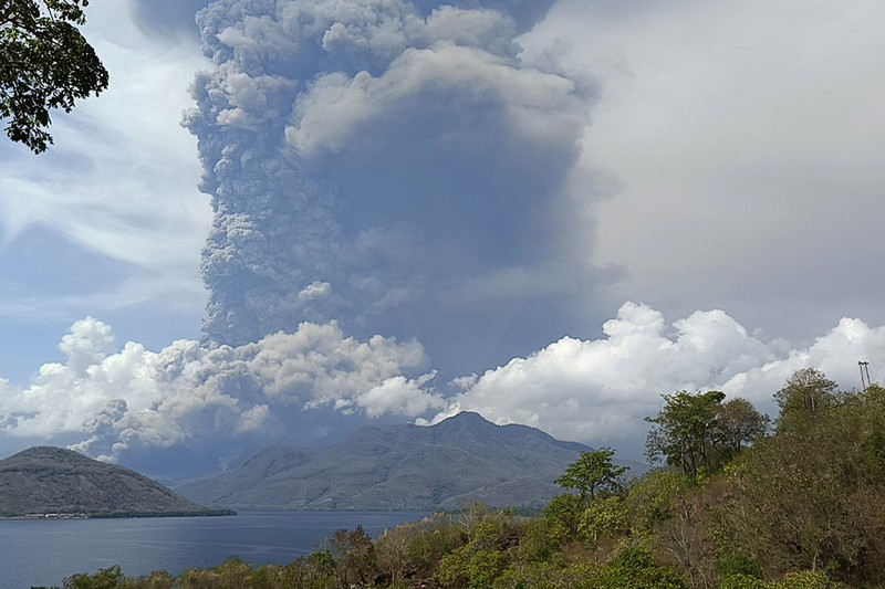 Warga berkendara dengan latar belakang Gunung Lewotobi Laki Laki memuntahkan material vulkanik saat terjadi letusan di Flores Timur, Indonesia, Sabtu, 9 November 2024.(Photo by ARNOLD WELIANTO / AFP) Warga berkendara dengan latar belakang Gunung Lewotobi Laki Laki memuntahkan material vulkanik saat terjadi letusan di Flores Timur, Indonesia, Sabtu, 9 November 2024.(Photo by ARNOLD WELIANTO / AFP)