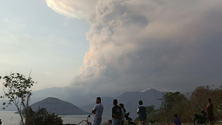 Warga menyaksikan Gunung Lewotobi Laki Laki memuntahkan material vulkanik saat terjadi letusan di Flores Timur, Indonesia, Sabtu, 9 November 2024. (AP Photo)