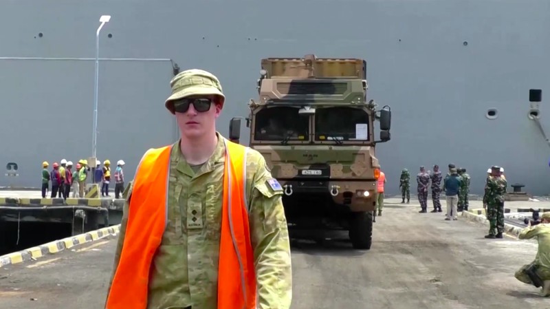 Anggota Angkatan Pertahanan Australia (ADF) dengan kapal perang mereka berlabuh di Banyuwangi di Jawa Timur, pada hari Minggu (10/11/2024). (Tangkapan Layar Video Reuters)