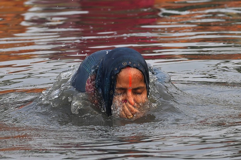 Festival keagamaan Hindu Chhath Puja tetap berlangsung khidmat meski buih-buih limbah menutupi Sungai Yamuna, New Delhi, India, Kamis (7/11). (REUTERS/Anushree Fadnavis)
