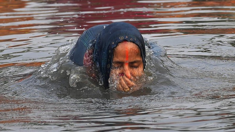 Festival keagamaan Hindu Chhath Puja tetap berlangsung khidmat meski buih-buih limbah menutupi Sungai Yamuna, New Delhi, India, Kamis (7/11). (REUTERS/Anushree Fadnavis)