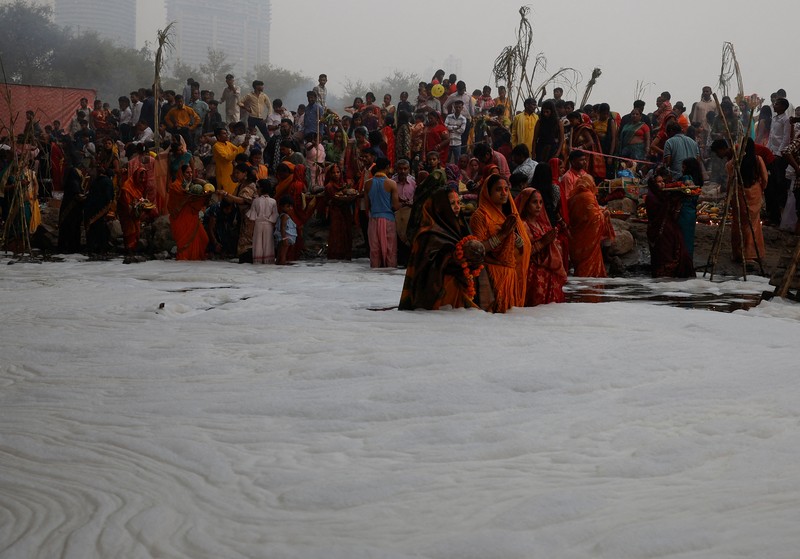 Festival keagamaan Hindu Chhath Puja tetap berlangsung khidmat meski buih-buih limbah menutupi Sungai Yamuna, New Delhi, India, Kamis (7/11). (REUTERS/Anushree Fadnavis)