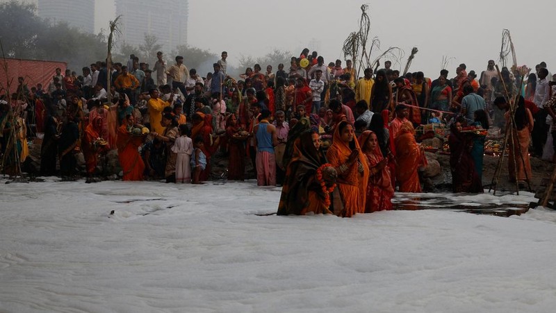 Festival keagamaan Hindu Chhath Puja tetap berlangsung khidmat meski buih-buih limbah menutupi Sungai Yamuna, New Delhi, India, Kamis (7/11). (REUTERS/Anushree Fadnavis)