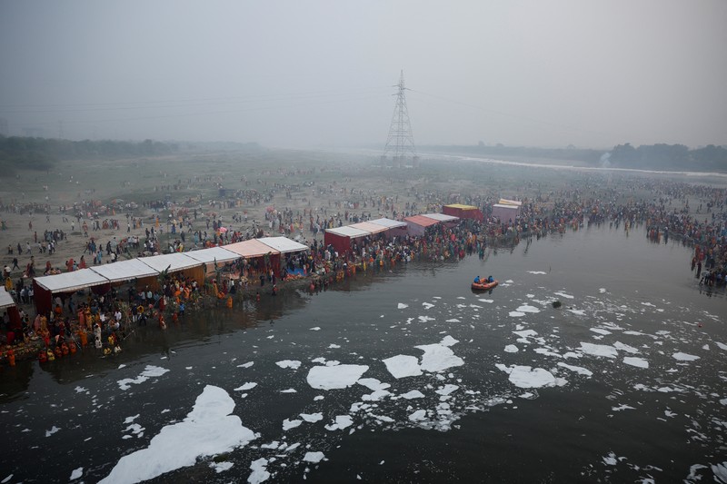 Festival keagamaan Hindu Chhath Puja tetap berlangsung khidmat meski buih-buih limbah menutupi Sungai Yamuna, New Delhi, India, Kamis (7/11). (REUTERS/Anushree Fadnavis)