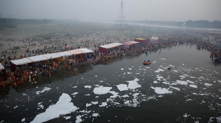 Festival keagamaan Hindu Chhath Puja tetap berlangsung khidmat meski buih-buih limbah menutupi Sungai Yamuna, New Delhi, India, Kamis (7/11). (REUTERS/Anushree Fadnavis)