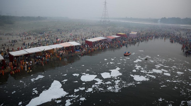 Festival keagamaan Hindu Chhath Puja tetap berlangsung khidmat meski buih-buih limbah menutupi Sungai Yamuna, New Delhi, India, Kamis (7/11). (REUTERS/Anushree Fadnavis)