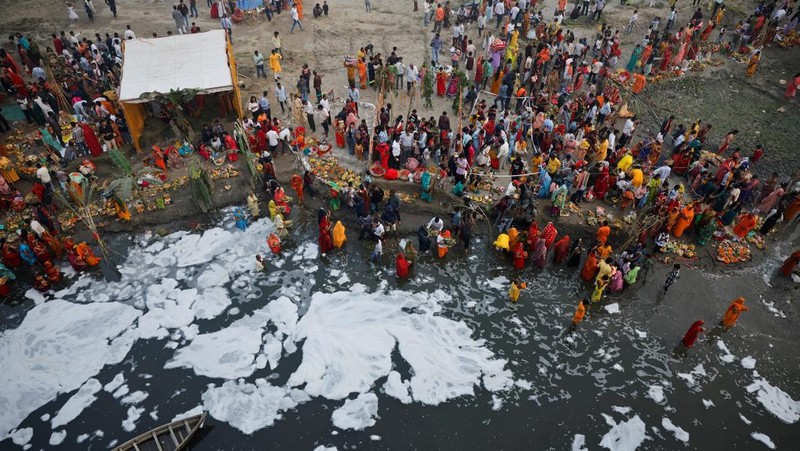 Festival keagamaan Hindu Chhath Puja tetap berlangsung khidmat meski buih-buih limbah menutupi Sungai Yamuna, New Delhi, India, Kamis (7/11). (REUTERS/Anushree Fadnavis)