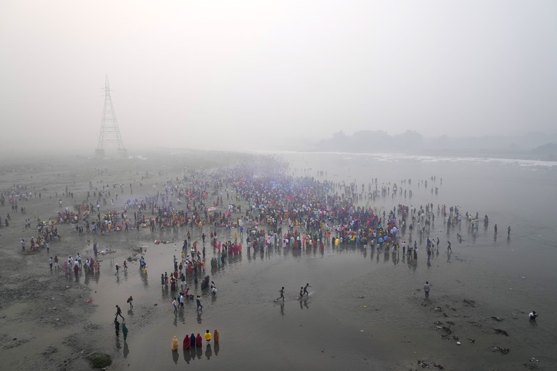 Festival keagamaan Hindu Chhath Puja tetap berlangsung khidmat meski buih-buih limbah menutupi Sungai Yamuna, New Delhi, India, Kamis (7/11). (REUTERS/Anushree Fadnavis)
