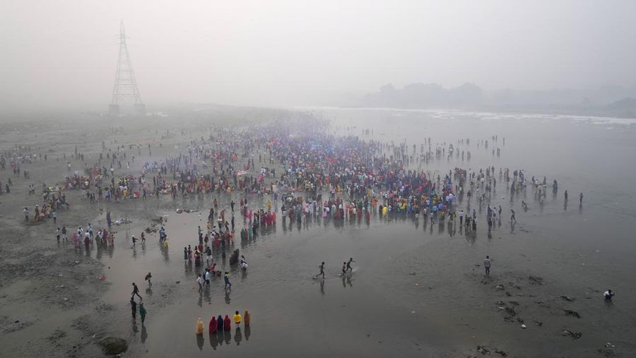 Festival keagamaan Hindu Chhath Puja tetap berlangsung khidmat meski buih-buih limbah menutupi Sungai Yamuna, New Delhi, India, Kamis (7/11). (REUTERS/Anushree Fadnavis)