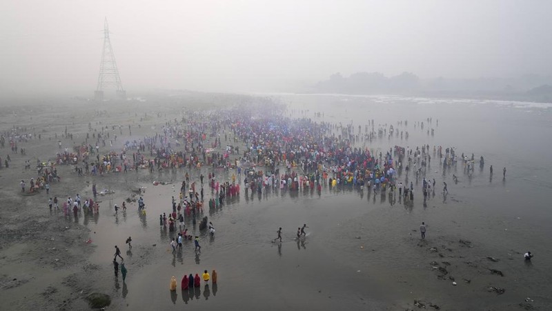 Festival keagamaan Hindu Chhath Puja tetap berlangsung khidmat meski buih-buih limbah menutupi Sungai Yamuna, New Delhi, India, Kamis (7/11). (REUTERS/Anushree Fadnavis)