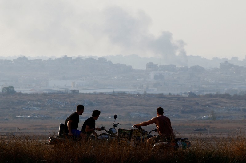 Warga Israel melihat Gaza utara dari sudut pandang dekat perbatasan, di tengah konflik yang sedang berlangsung di Gaza antara Israel dan Hamas, seperti yang terlihat dari Israel, 9 November 2024. (REUTERS/Amir Cohen)