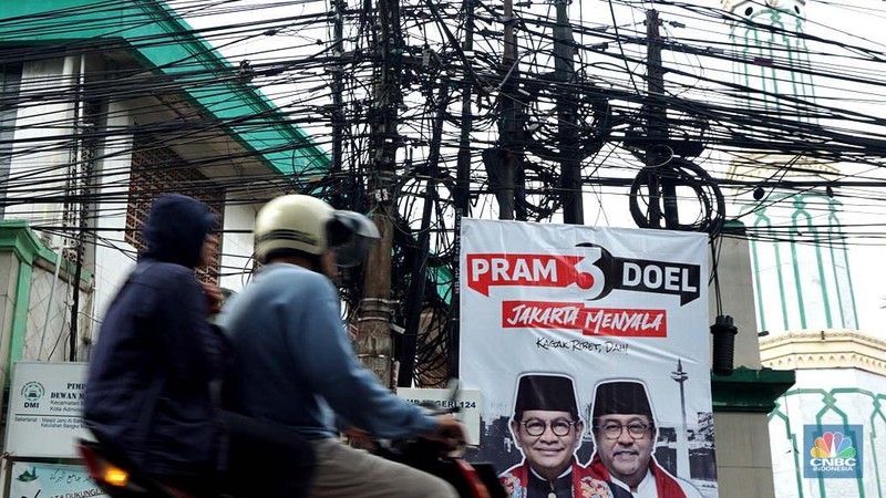 Jaringan kabel utilitas semrawut di Jalan Raya Kemang, Jakarta Rabu (13/11/2024). Semrawutnya jaringan kabel utilitas itu dikeluhkan warga karena selain mengurangi kenyamanan dan keindahan kota, juga berpotensi membahayakan pengguna jalan. (CNBC Indonesia/Muhammad Sabki)