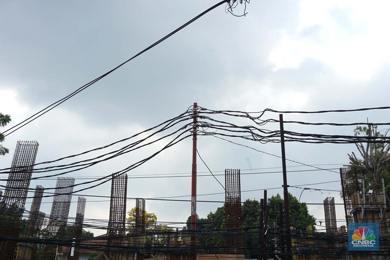 Jaringan kabel utilitas semrawut di Jalan Raya Kemang, Jakarta Rabu (13/11/2024). Semrawutnya jaringan kabel utilitas itu dikeluhkan warga karena selain mengurangi kenyamanan dan keindahan kota, juga berpotensi membahayakan pengguna jalan. (CNBC Indonesia/Muhammad Sabki)
