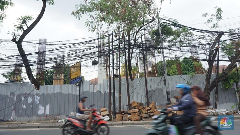 Jaringan kabel utilitas semrawut di Jalan Raya Kemang, Jakarta Rabu (13/11/2024). Semrawutnya jaringan kabel utilitas itu dikeluhkan warga karena selain mengurangi kenyamanan dan keindahan kota, juga berpotensi membahayakan pengguna jalan. (CNBC Indonesia/Muhammad Sabki)