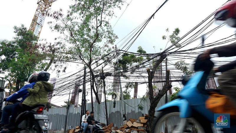 Jaringan kabel utilitas semrawut di Jalan Raya Kemang, Jakarta Rabu (13/11/2024). Semrawutnya jaringan kabel utilitas itu dikeluhkan warga karena selain mengurangi kenyamanan dan keindahan kota, juga berpotensi membahayakan pengguna jalan. (CNBC Indonesia/Muhammad Sabki)