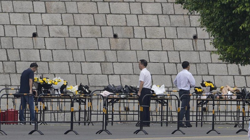 Orang-orang membakar dupa di dekat karangan bunga di luar pusat olahraga tempat serangan tabrak lari mematikan terjadi, di Zhuhai, Guangdong, China, (12/11/2024). (REUTERS/Tingshu Wang)