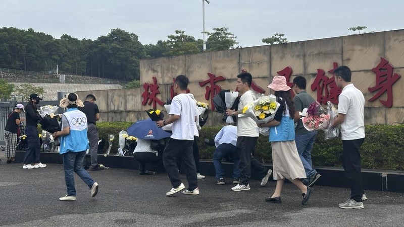 Orang-orang membakar dupa di dekat karangan bunga di luar pusat olahraga tempat serangan tabrak lari mematikan terjadi, di Zhuhai, Guangdong, China, (12/11/2024). (REUTERS/Tingshu Wang)