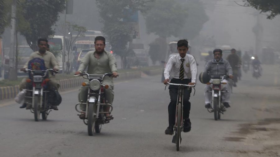 Pengendara sepeda motor melaju di jalan saat kabut asap menyelimuti wilayah Peshawar, Pakistan, Senin, 11 November 2024. (AP/Muhammad Sajjad)
