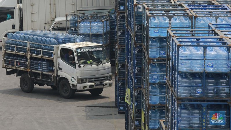 Sejumlah pekerja mengangkut air minum dalam kemasan (AMDK) galon dengan alat pemberat di distributor Aqua di kawasan Jakarta, Kamis, (14/11/2024). (CNBC Indonesia/Muhammad Sabki)