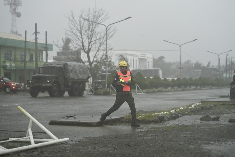 Seorang pria mendorong sepeda motornya di tengah hujan lebat akibat Topan Usagi di Santa Ana, provinsi Cagayan, Filipina utara pada Kamis, 14 November 2024. (AP Photo/Noel Celis)