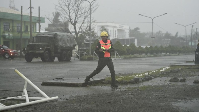 Seorang pria mendorong sepeda motornya di tengah hujan lebat akibat Topan Usagi di Santa Ana, provinsi Cagayan, Filipina utara pada Kamis, 14 November 2024. (AP Photo/Noel Celis)