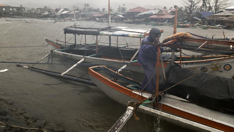 Seorang pria mendorong sepeda motornya di tengah hujan lebat akibat Topan Usagi di Santa Ana, provinsi Cagayan, Filipina utara pada Kamis, 14 November 2024. (AP Photo/Noel Celis)