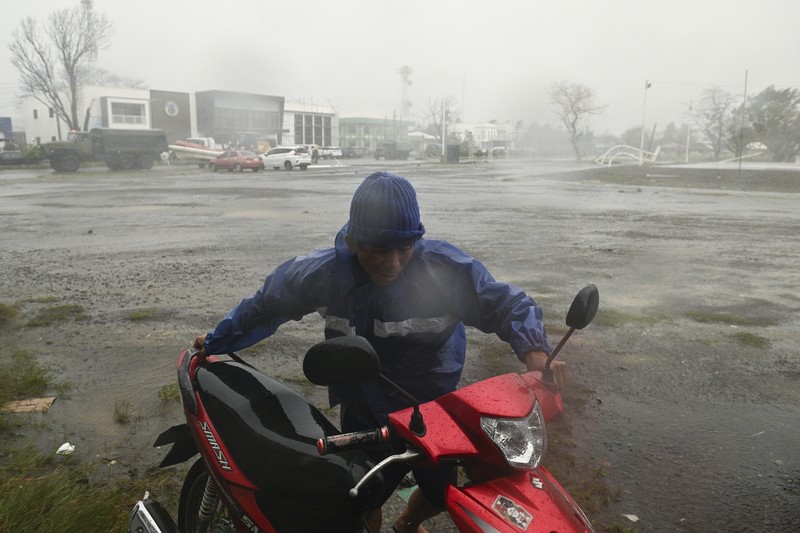 Seorang pria mendorong sepeda motornya di tengah hujan lebat akibat Topan Usagi di Santa Ana, provinsi Cagayan, Filipina utara pada Kamis, 14 November 2024. Seorang pria mendorong sepeda motornya di tengah hujan lebat akibat Topan Usagi di Santa Ana, provinsi Cagayan, Filipina utara pada Kamis, 14 November 2024. (AP Photo/Noel Celis)