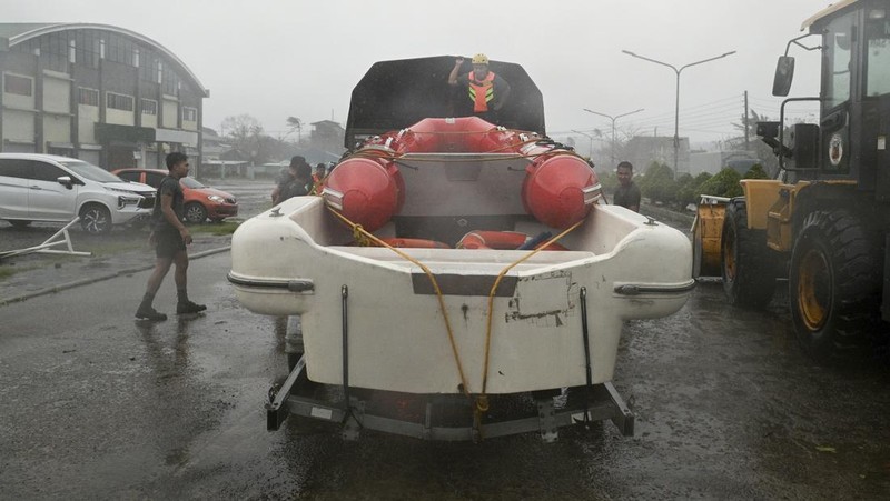 Seorang pria mendorong sepeda motornya di tengah hujan lebat akibat Topan Usagi di Santa Ana, provinsi Cagayan, Filipina utara pada Kamis, 14 November 2024. (AP Photo/Noel Celis)