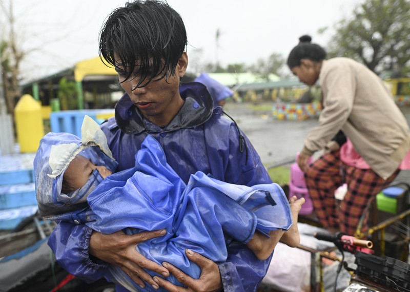 Seorang pria mendorong sepeda motornya di tengah hujan lebat akibat Topan Usagi di Santa Ana, provinsi Cagayan, Filipina utara pada Kamis, 14 November 2024. (AP Photo/Noel Celis)