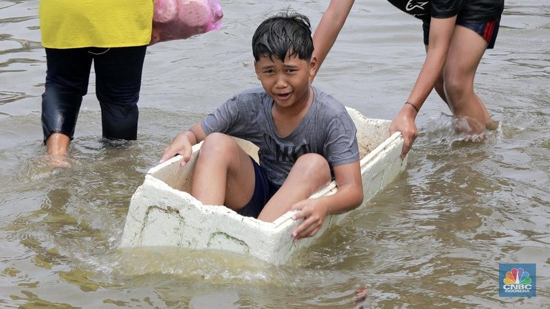 Sejumlah warga beraktivitas di wilayah yang tergenang rob di Penjaringan, Jakarta Utara, Jumat (15/11/2024). (CNBC Indonesia/Muhammad Sabki)