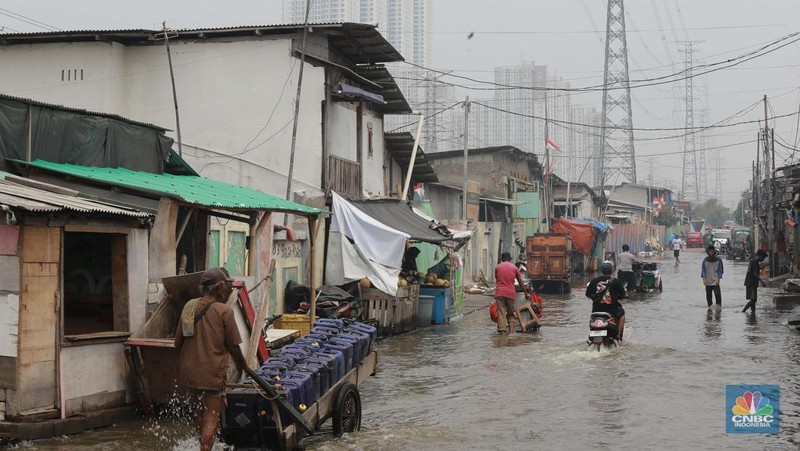 Sejumlah warga beraktivitas di wilayah yang tergenang rob di Penjaringan, Jakarta Utara, Jumat (15/11/2024). (CNBC Indonesia/Muhammad Sabki)