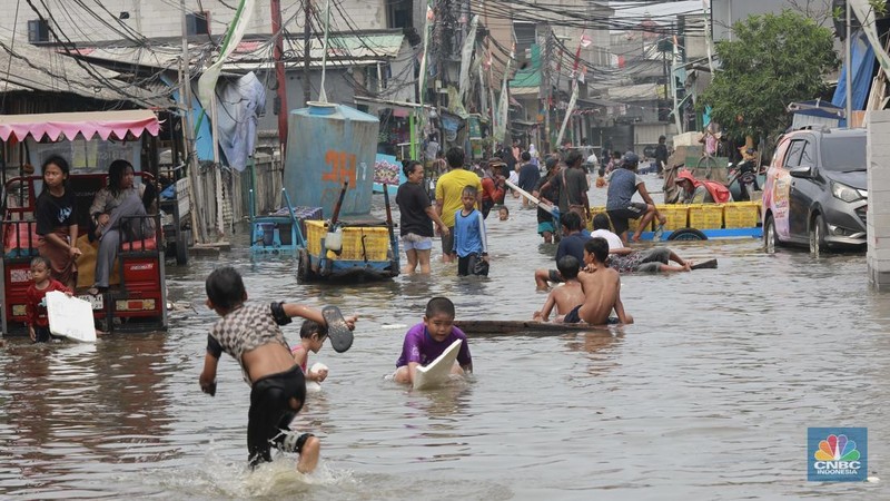 Sejumlah warga beraktivitas di wilayah yang tergenang rob di Penjaringan, Jakarta Utara, Jumat (15/11/2024). (CNBC Indonesia/Muhammad Sabki)