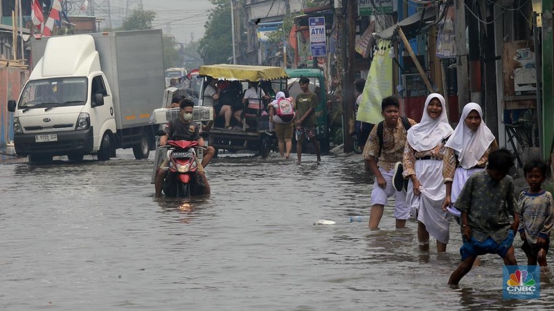 Sejumlah warga beraktivitas di wilayah yang tergenang rob di Penjaringan, Jakarta Utara, Jumat (15/11/2024). (CNBC Indonesia/Muhammad Sabki)