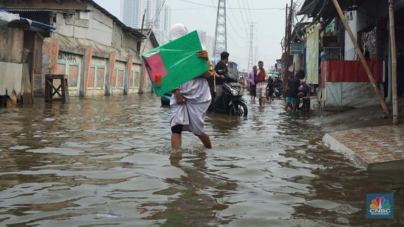 Sejumlah warga beraktivitas di wilayah yang tergenang rob di Penjaringan, Jakarta Utara, Jumat (15/11/2024). (CNBC Indonesia/Muhammad Sabki)