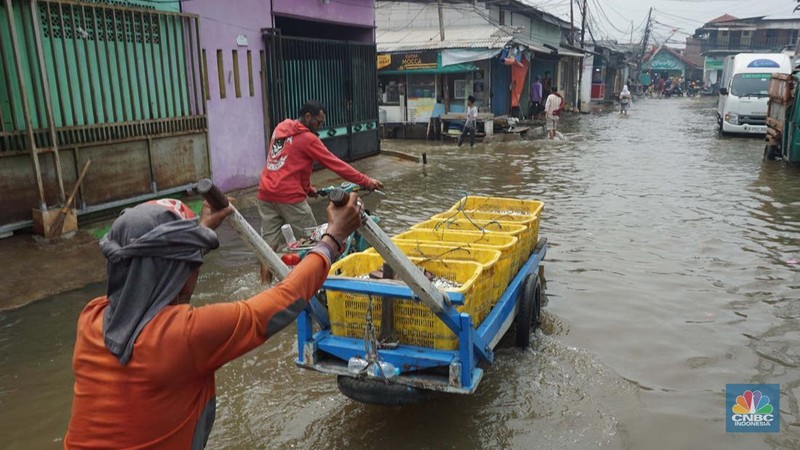 Sejumlah warga beraktivitas di wilayah yang tergenang rob di Penjaringan, Jakarta Utara, Jumat (15/11/2024). (CNBC Indonesia/Muhammad Sabki)