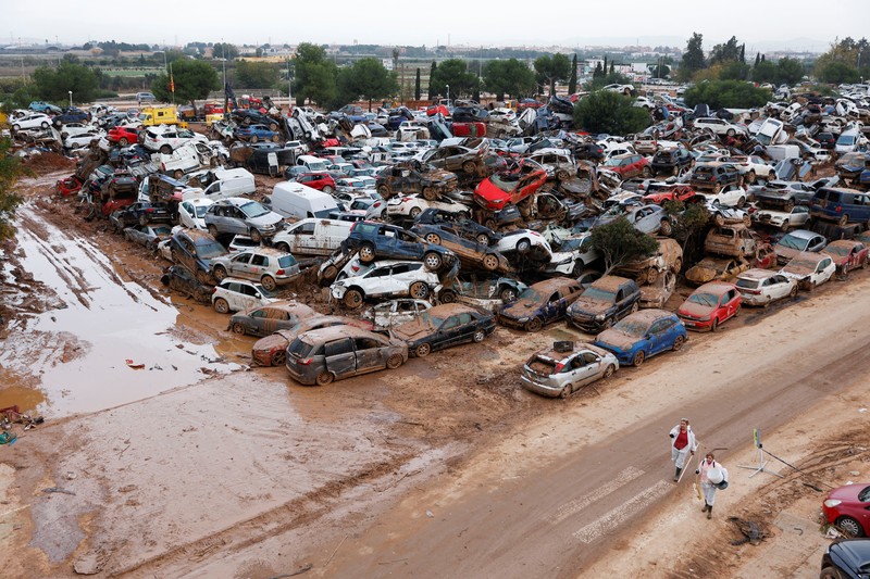 Sebuah pemandangan menunjukkan lokasi tempat mobil-mobil yang rusak dan menumpuk akibat hujan lebat di Catarroja, Valencia, Spanyol, Sabtu (16/11/2024). (REUTERS/Eva Manez)