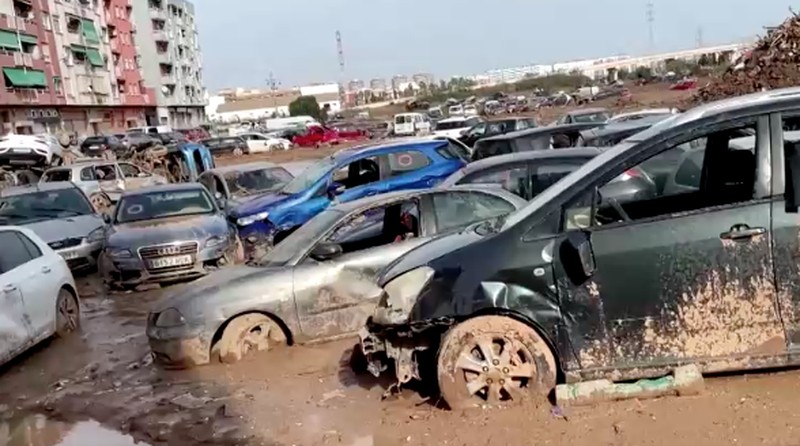 Sebuah pemandangan menunjukkan lokasi tempat mobil-mobil yang rusak dan menumpuk akibat hujan lebat di Catarroja, Valencia, Spanyol, Sabtu (16/11/2024). (REUTERS/Eva Manez)