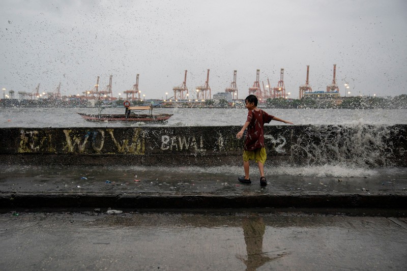Anak-anak bermain di dekat ombak kencang dari Sungai Pasig di tengah Topan Hebat Man-yi, di Manila, Filipina, 17 November 2024. (REUTERS/Lisa Marie David) Anak-anak bermain di dekat ombak kencang dari Sungai Pasig di tengah Topan Hebat Man-yi, di Manila, Filipina, 17 November 2024. (REUTERS/Lisa Marie David)