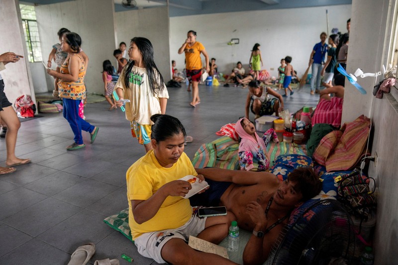 Anak-anak bermain di dekat ombak kencang dari Sungai Pasig di tengah Topan Hebat Man-yi, di Manila, Filipina, 17 November 2024. (REUTERS/Lisa Marie David)