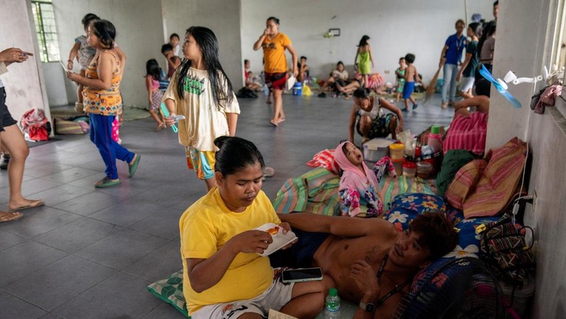 Anak-anak bermain di dekat ombak kencang dari Sungai Pasig di tengah Topan Hebat Man-yi, di Manila, Filipina, 17 November 2024. (REUTERS/Lisa Marie David)