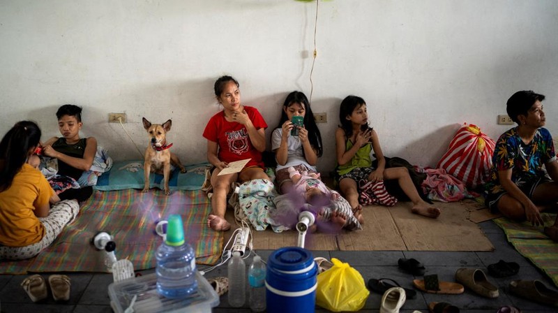 Anak-anak bermain di dekat ombak kencang dari Sungai Pasig di tengah Topan Hebat Man-yi, di Manila, Filipina, 17 November 2024. (REUTERS/Lisa Marie David)