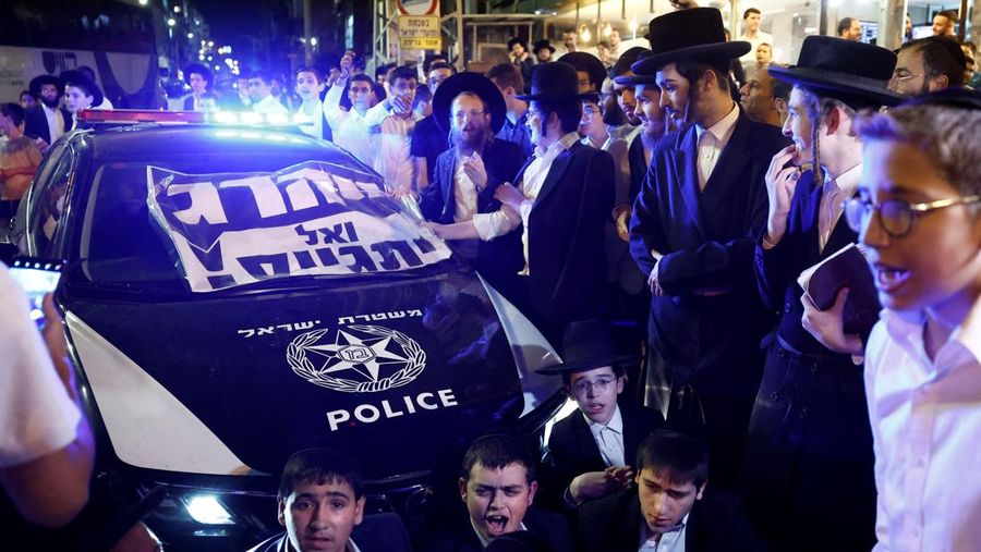 Kaum Yahudi ultra-Ortodoks Israel berunjuk rasa setelah militer Israel mengeluarkan pemberitahuan panggilan kepada lebih banyak anggota komunitas mereka untuk memperkuat pasukannya, di tengah konflik yang sedang berlangsung di Gaza antara Israel dan Hamas serta permusuhan lintas perbatasan dengan Hizbullah di Lebanon, di Bnei Brak, Israel, 17 November 2024. (REUTERS/Thomas Peter)