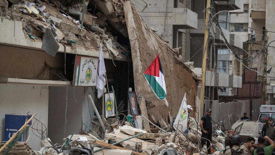 Orang-orang berdiri di atas reruntuhan setelah serangan Israel terhadap sebuah gedung yang menurut sumber keamanan menewaskan kepala hubungan media Hizbullah Mohammad Afif di Ras Al-Nabaa, di Beirut, Lebanon, 17 November 2024. (REUTERS/Adnan Abidi)
