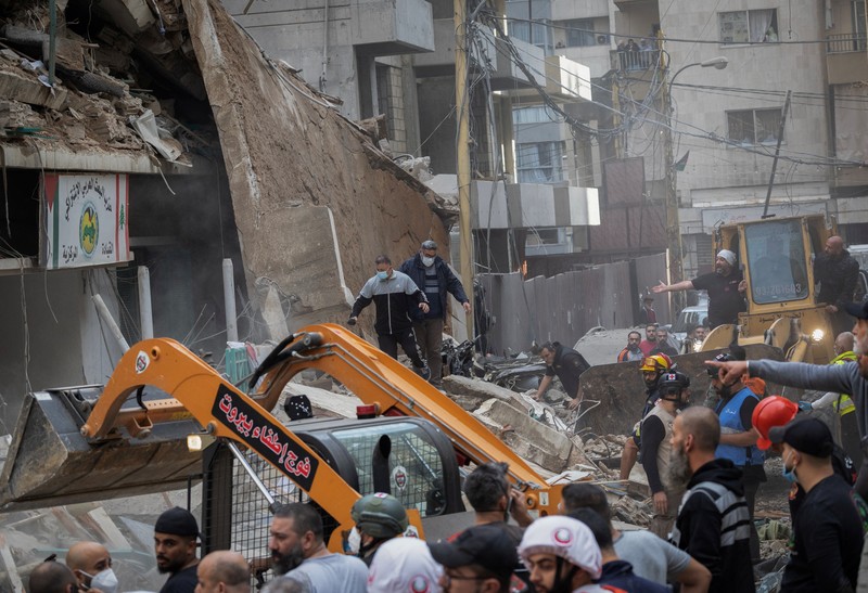 Orang-orang dan tim penyelamat berkumpul di lokasi serangan Israel terhadap sebuah gedung yang menurut sumber keamanan menewaskan kepala hubungan media Hizbullah Mohammad Afif di Ras Al-Nabaa, di Beirut, Lebanon, 17 November 2024. Orang-orang dan tim penyelamat berkumpul di lokasi serangan Israel terhadap sebuah gedung yang menurut sumber keamanan menewaskan kepala hubungan media Hizbullah Mohammad Afif di Ras Al-Nabaa, di Beirut, Lebanon, 17 November 2024. (REUTERS/Adnan Abidi)