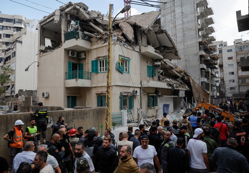 Orang-orang dan tim penyelamat berkumpul di lokasi serangan Israel terhadap sebuah gedung yang menurut sumber keamanan menewaskan kepala hubungan media Hizbullah Mohammad Afif di Ras Al-Nabaa, di Beirut, Lebanon, 17 November 2024. Orang-orang dan tim penyelamat berkumpul di lokasi serangan Israel terhadap sebuah gedung yang menurut sumber keamanan menewaskan kepala hubungan media Hizbullah Mohammad Afif di Ras Al-Nabaa, di Beirut, Lebanon, 17 November 2024. (REUTERS/Adnan Abidi)
