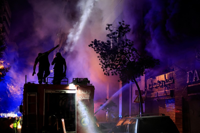 Petugas pemadam kebakaran bekerja memadamkan api di lokasi serangan Israel di jalan Mar Elias Beirut, Lebanon 17 November 2024. (REUTERS/Thaier Al-Sudani)