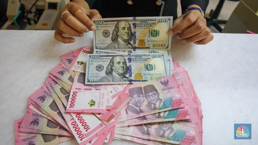 Petugas menunjukkan uang pecahan dolar AS dan rupiah di gerai penukaran mata uang asing di tempat penukaran uang PT Ayu Masagung, Jakarta, Senin (18/11/2024). (վ/Faisal Rahman)