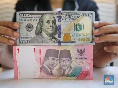 Petugas menunjukkan uang pecahan dolar AS dan rupiah di gerai penukaran mata uang asing di tempat penukaran uang PT Ayu Masagung, Jakarta, Senin (18/11/2024). (CNBC Indonesia/Faisal Rahman)