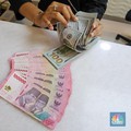 Petugas menunjukkan uang pecahan dolar AS dan rupiah di gerai penukaran mata uang asing di tempat penukaran uang PT Ayu Masagung, Jakarta, Senin (18/11/2024). (CNBC Indonesia/Faisal Rahman)